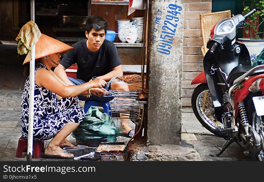 Photography of Man and Woman Grilling Food