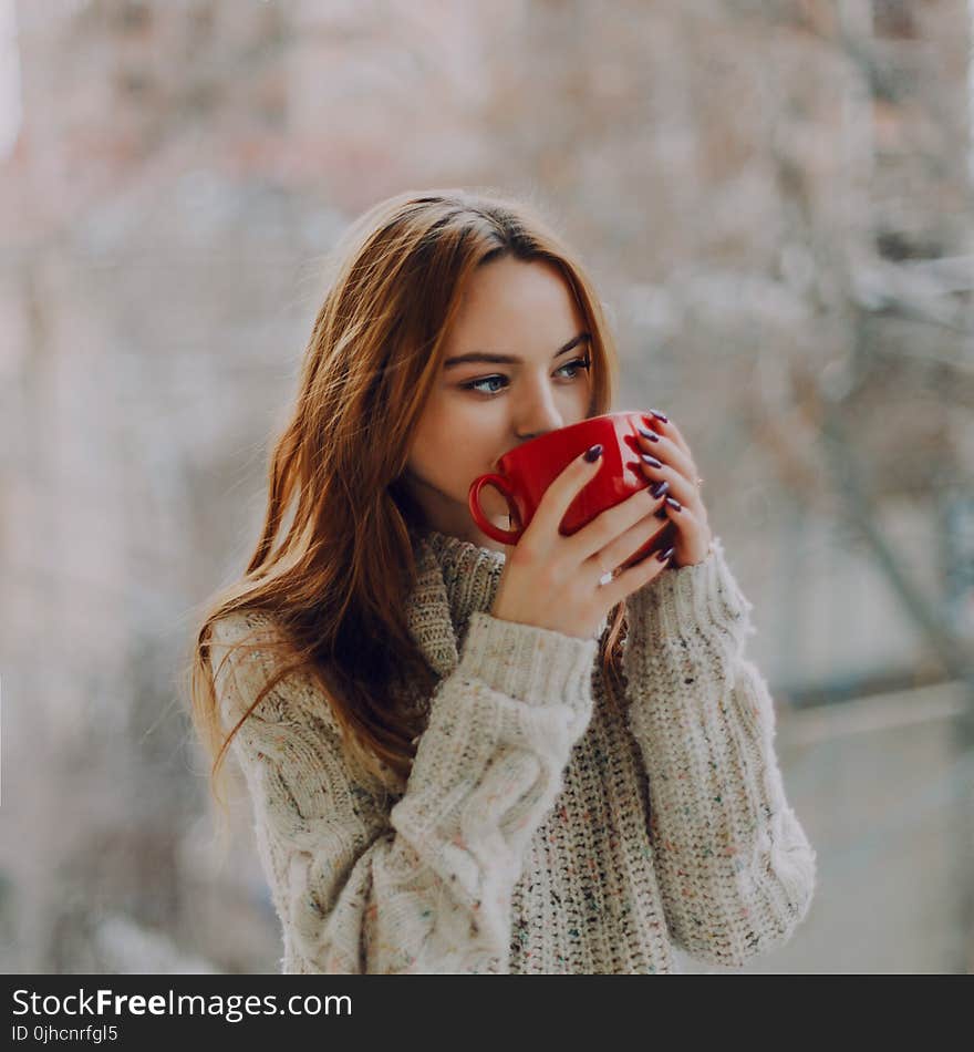 Selective Focus Photography of Woman Holding Red Ceramic Cup