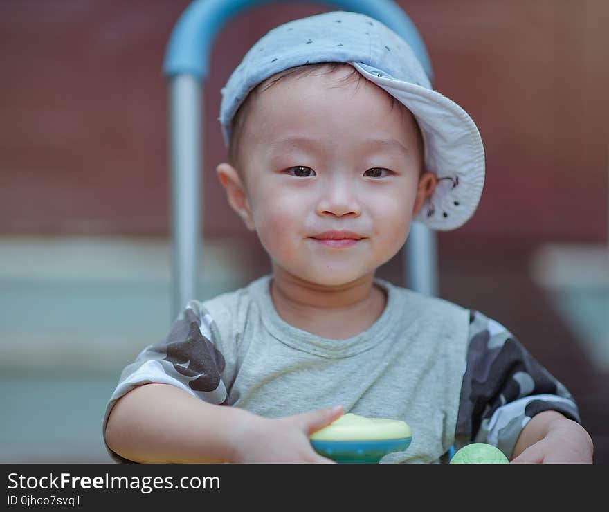 Depth of Field Photo of Boy Wearing Blue Cap