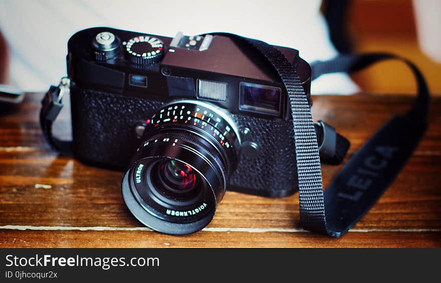 Black Dslr Camera on Top of Brown Wooden Table