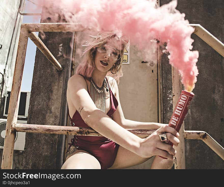 Woman in Maroon Monokini Holding Dynamite