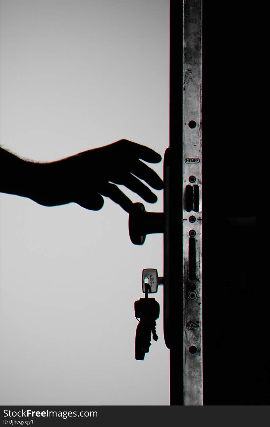 Silhouette Photo of Person Holding Door Knob