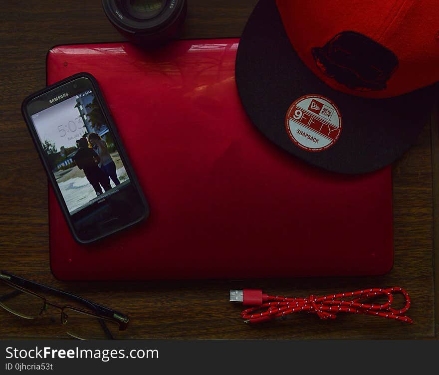 Red and Black New Era 9fifty Snapback Cap and Black Samsung Galaxy Android Smartphone