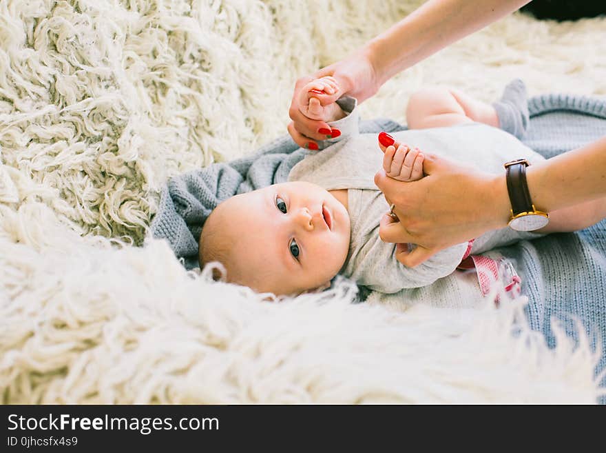 Baby in Gray Long-sleeved Onesie Lying on Beige Fur Textile