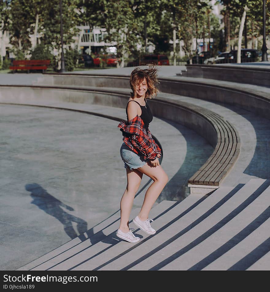 Photo of Woman in Black Tank Top Walking on Stairs at a Park