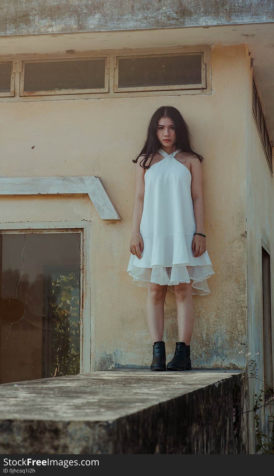 Woman in White Dress Standing on Concrete Wall