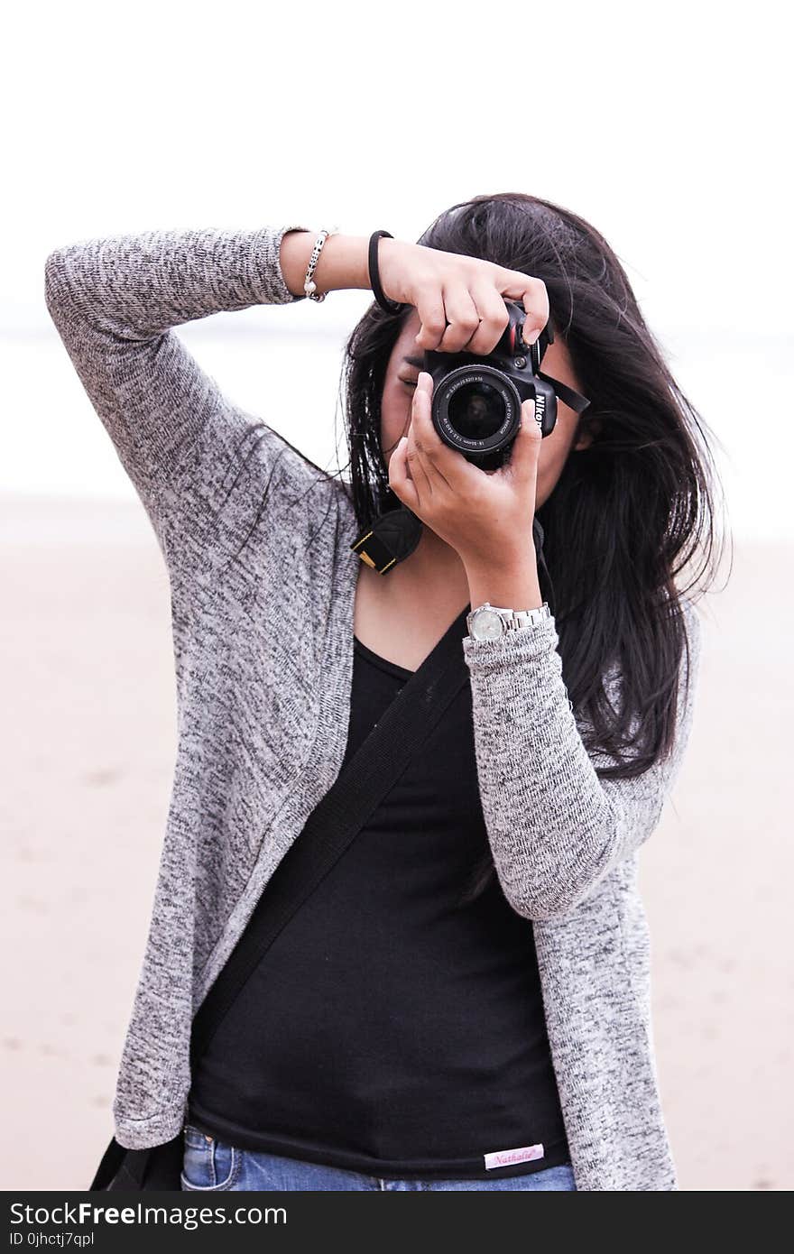 Woman in Gray Cardigan and Black Shirt Holding Black Dslr Camera