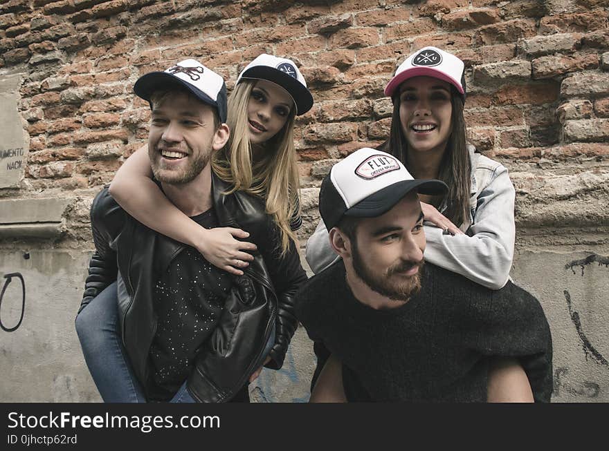 Photo of Two Men Carrying Two Women on Back