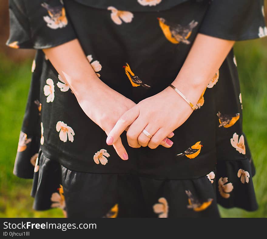 Close Up Photo of Person Wearing Black and Orange Floral Dress