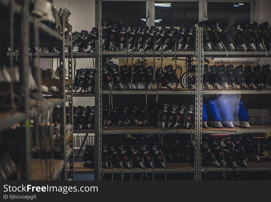 Black and Blue Ice Skates on Gray Metal Shelf Inside White Room