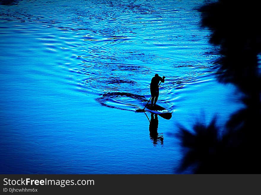 Silhouette of Person Paddling Boat