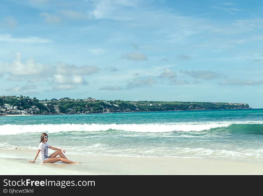 Woman Sitting on Seashore