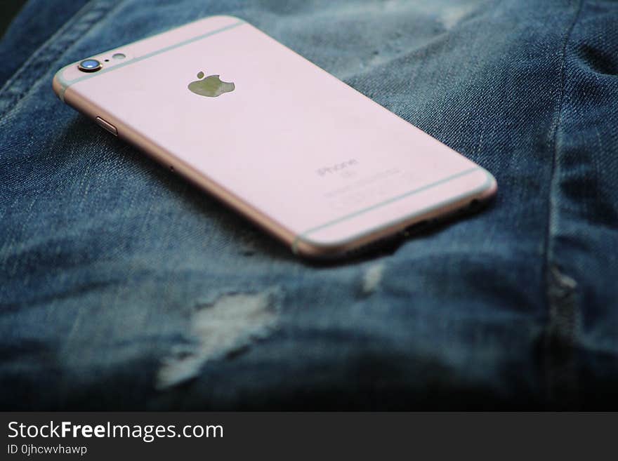 Close-Up Photography of Rose Gold Iphone 6s on Top of Blue Denim Jeans