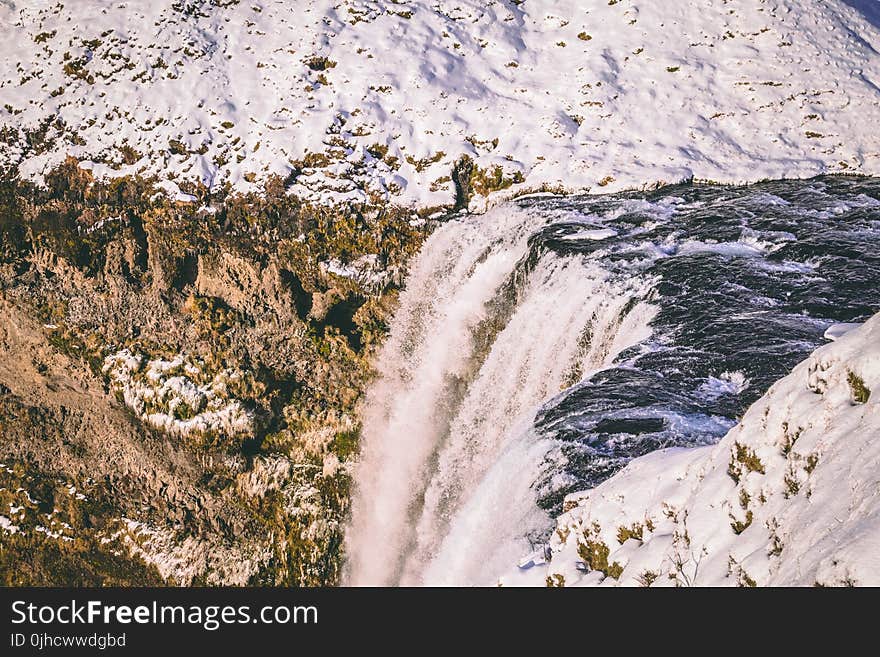 Water Falls Beside Mountains With Snow