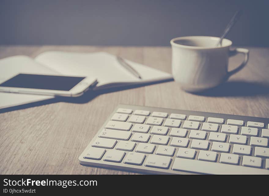 Magic Keyboard Beside Coffee Mug on Desk