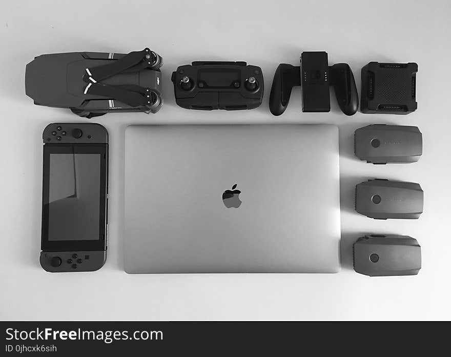 Silver Macbook Surrounding Black Electronic Devices