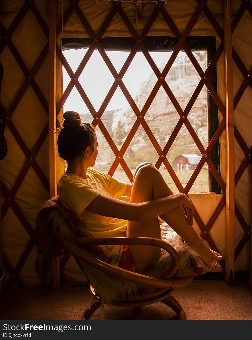 Photography Of Woman Sitting On Brown Wicker Chair During Sunset