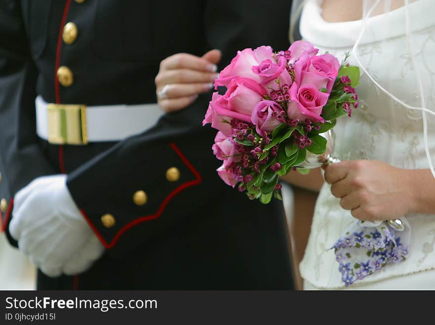 Woman Holding Pink Rose Wedding Bouquet Wearing White Wedding Dress