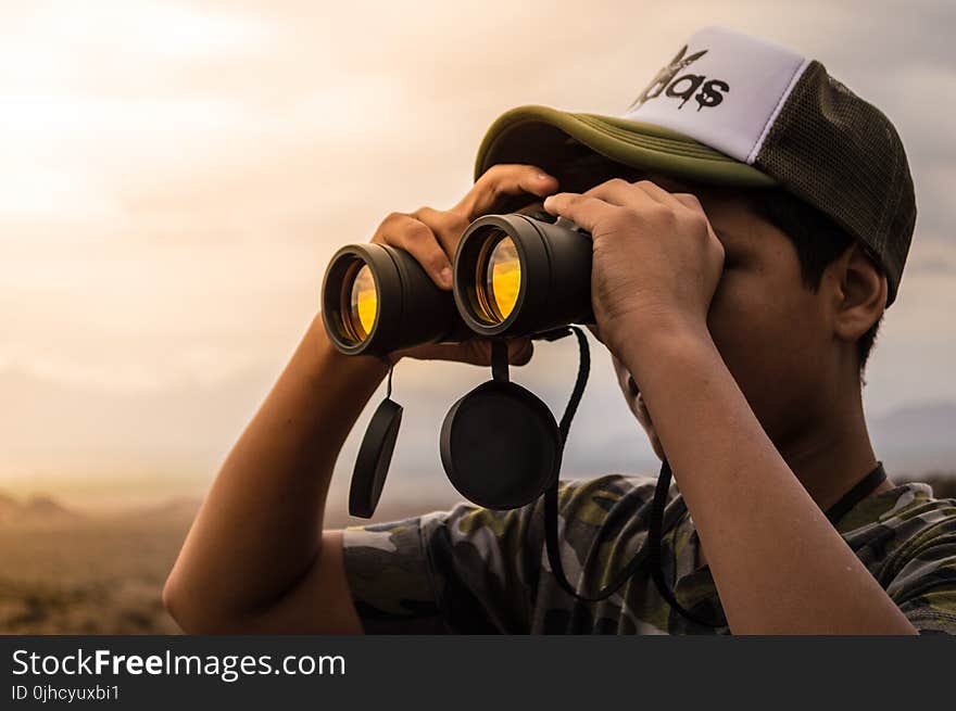 Man Looking in Binoculars during Sunset