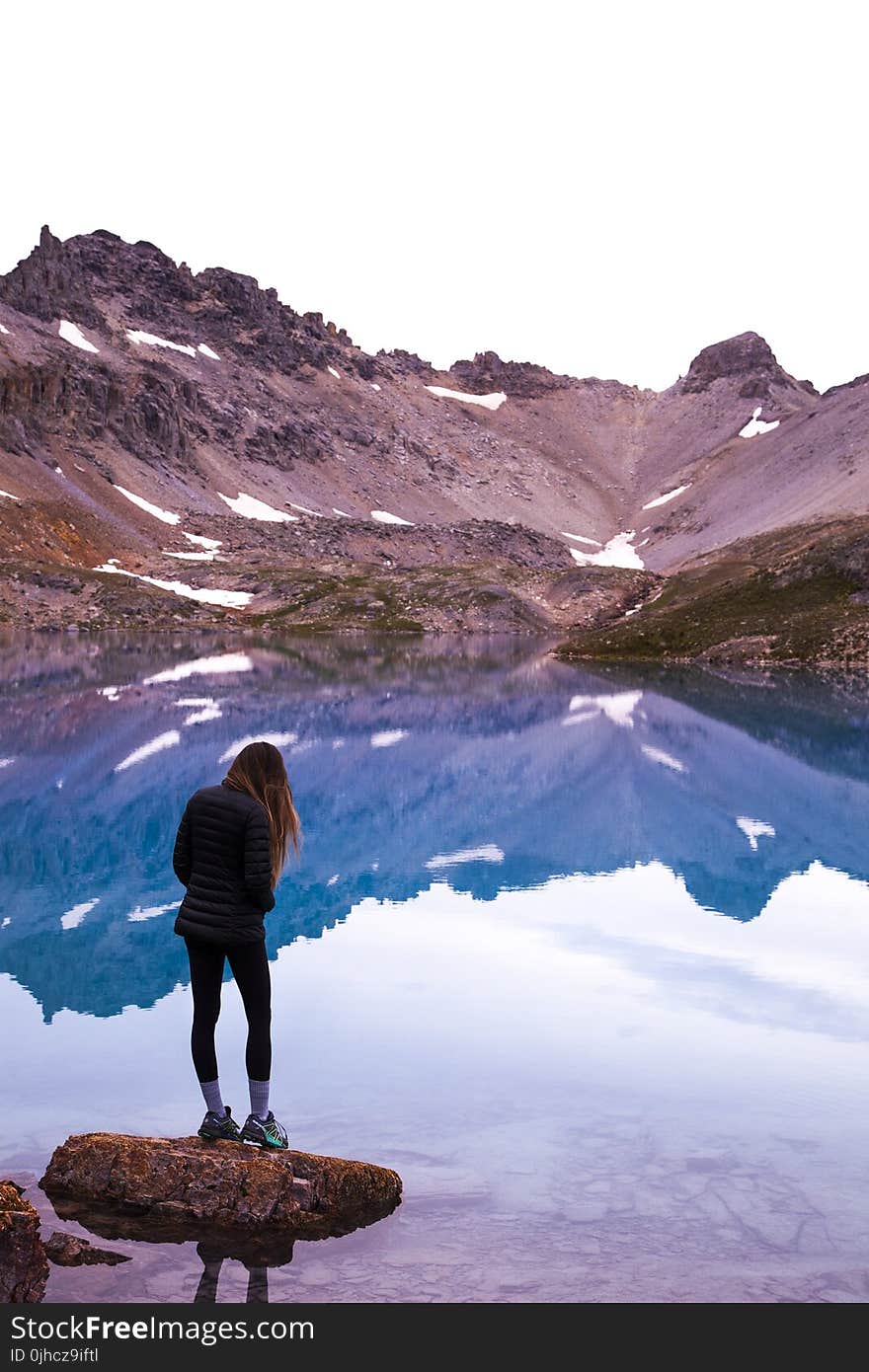 Woman Standing On Rock By The Lake And Mountain