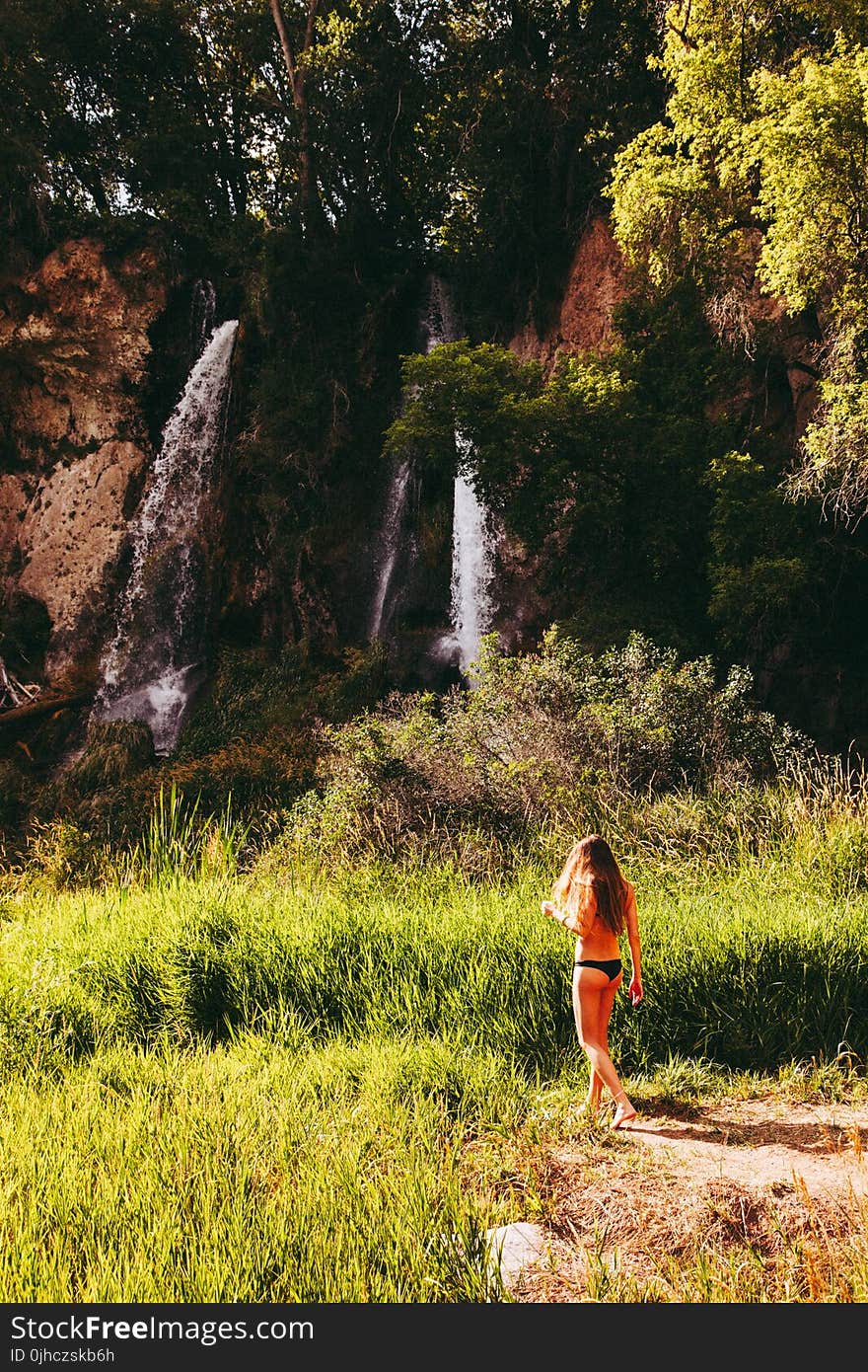 Woman In Black Bikini Bottom Walking Towards Waterfall