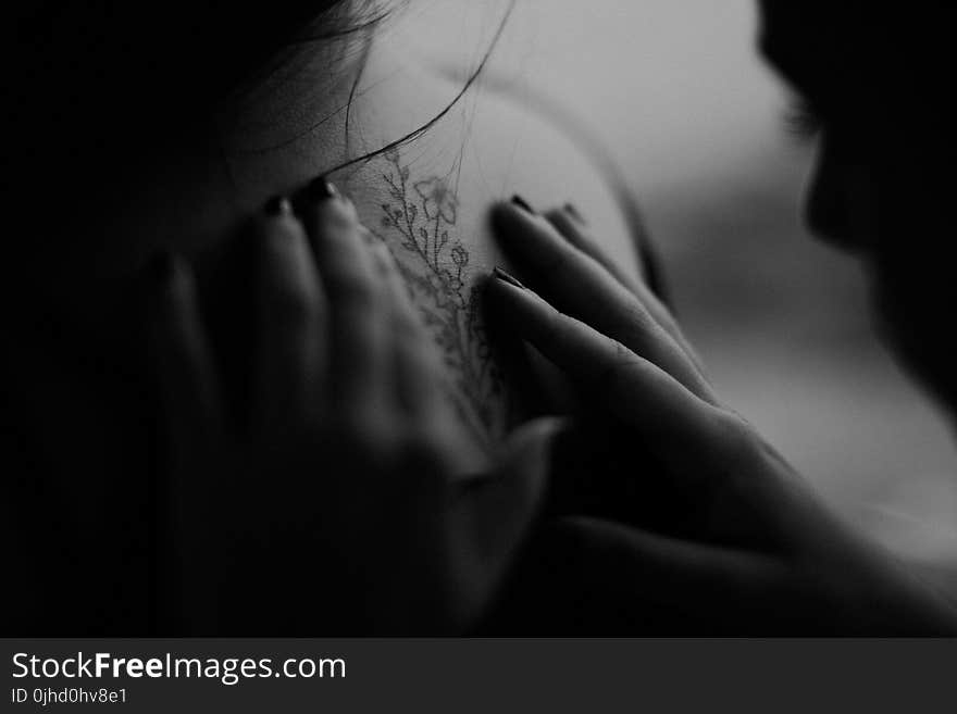 Grayscale Photo of Man Looking at Woman&#x27;s Back Flower Tattoo