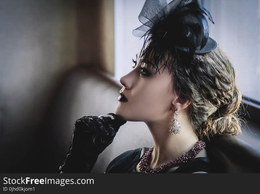 Woman Wearing Black Dress Sitting on Sofa