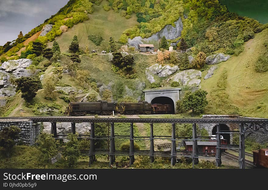 Green and Grey Mountains With Train Trail Going Inside