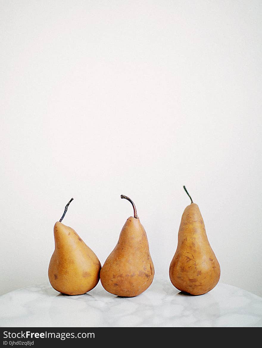 Three Brown Fruits on White Textile