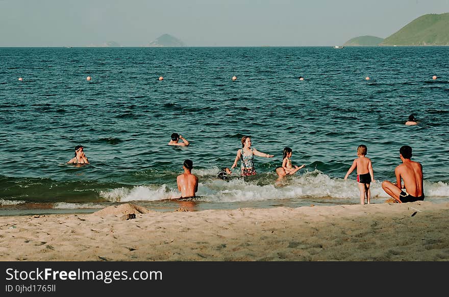 Photography of People Swimming in the Beach