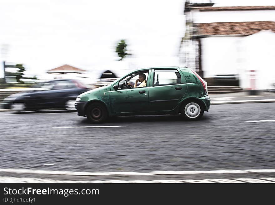 Photography of a Person Driving Green Car