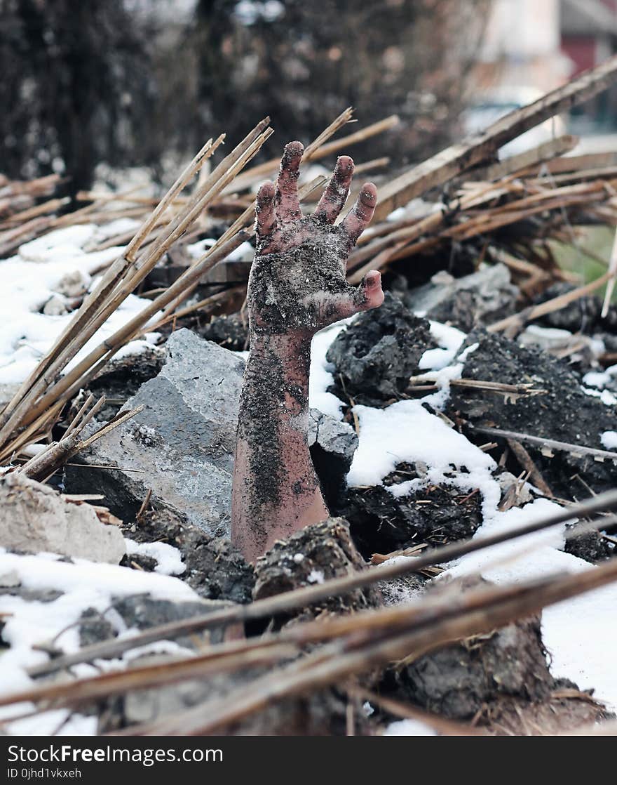 Person Buried Under Grey Stone and Black Soils