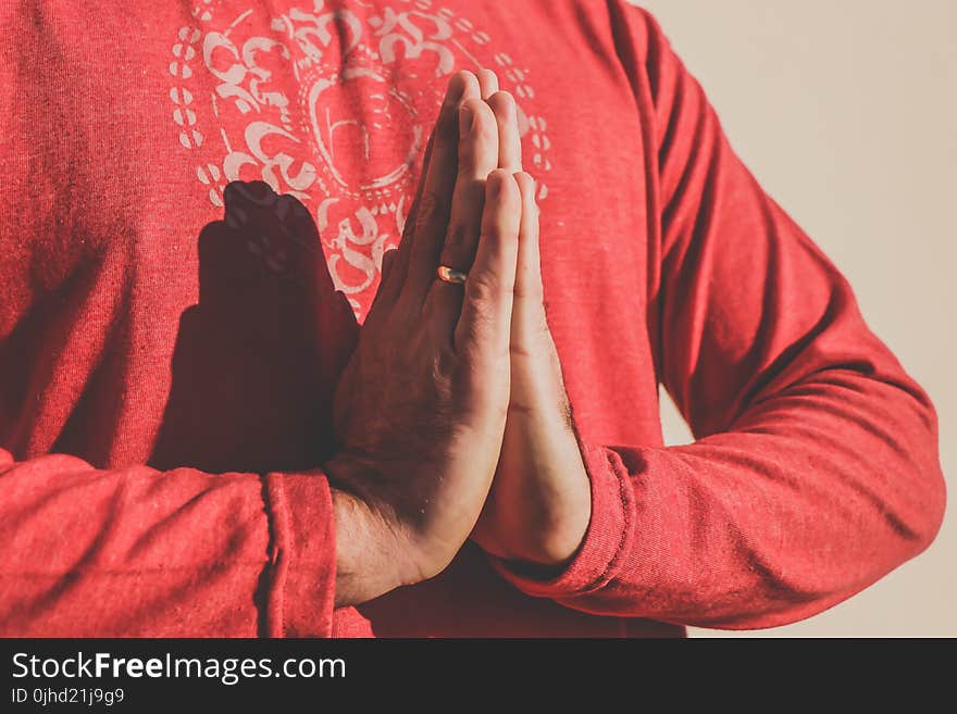 Person Wearing Gold Ring and Red Long Sleeve Top