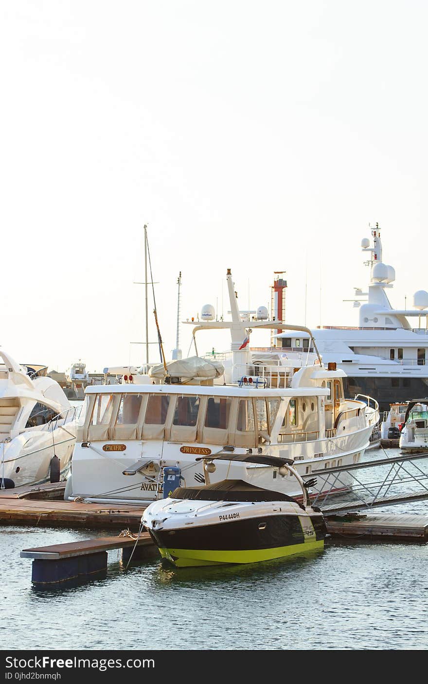 White Yacht Parked on Wooden Dock