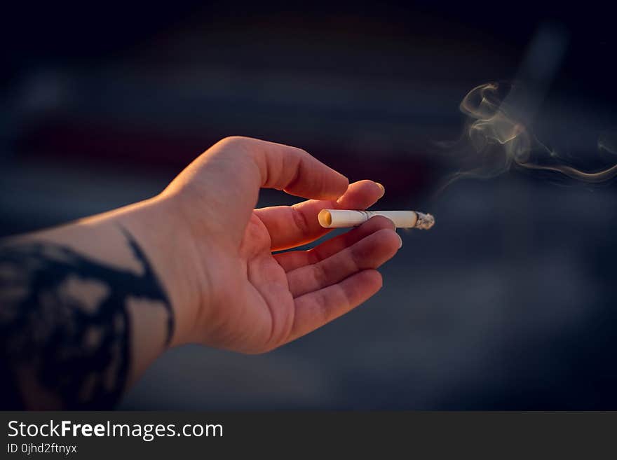 Close-Up Photography of a Person Holding Cigarette