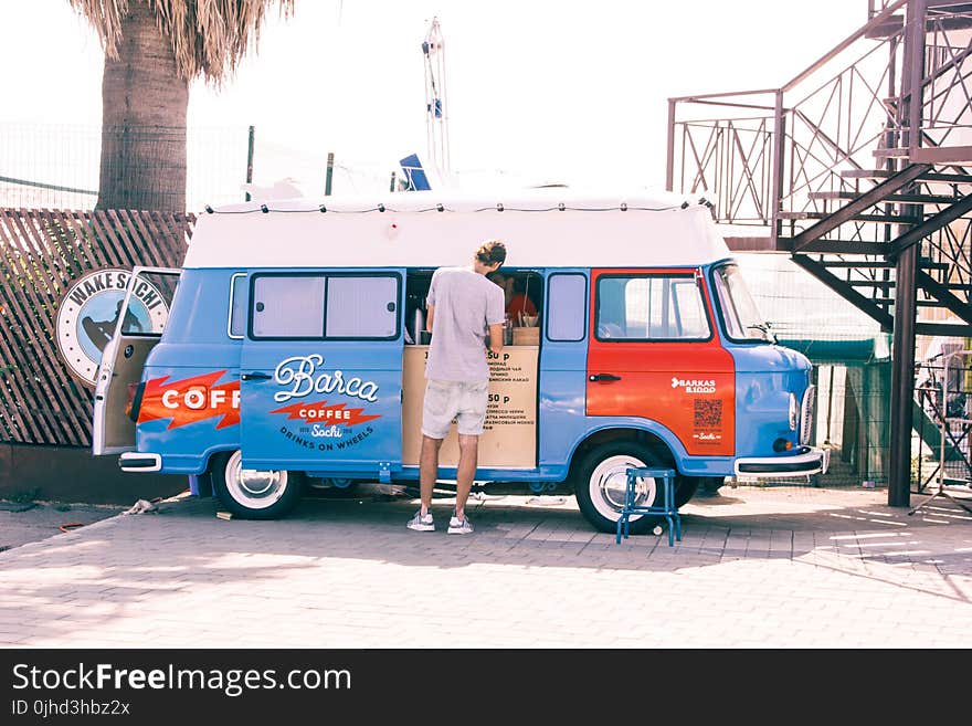 Man Wearing White Shorts in Front of Volkswagen Beetle Type 2