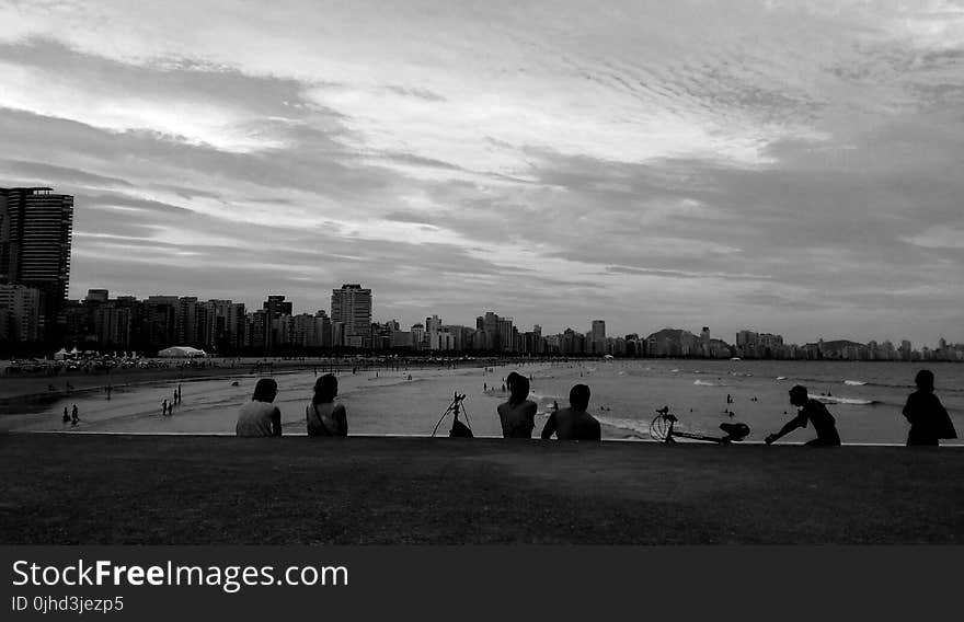 Gray Scale Photo of Group of People Near on Beach