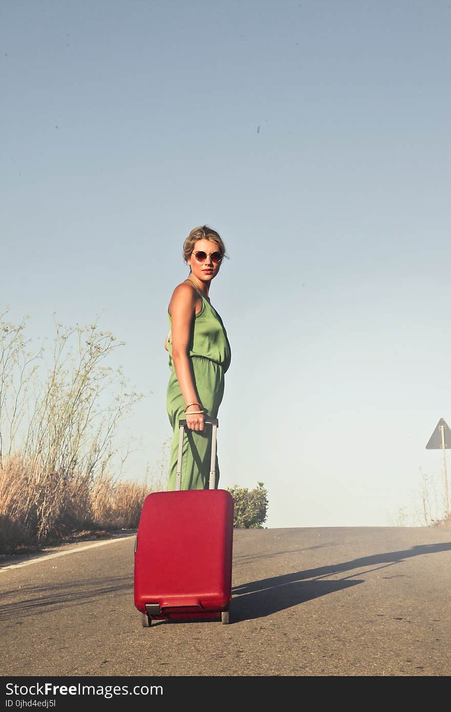 Photo of a Woman Holding her Luggae