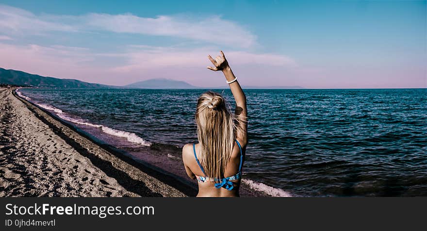 Woman in Blue Bikini Standing Beside Shore