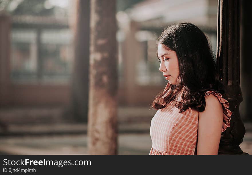 Photography of Woman Leaning on Black Post