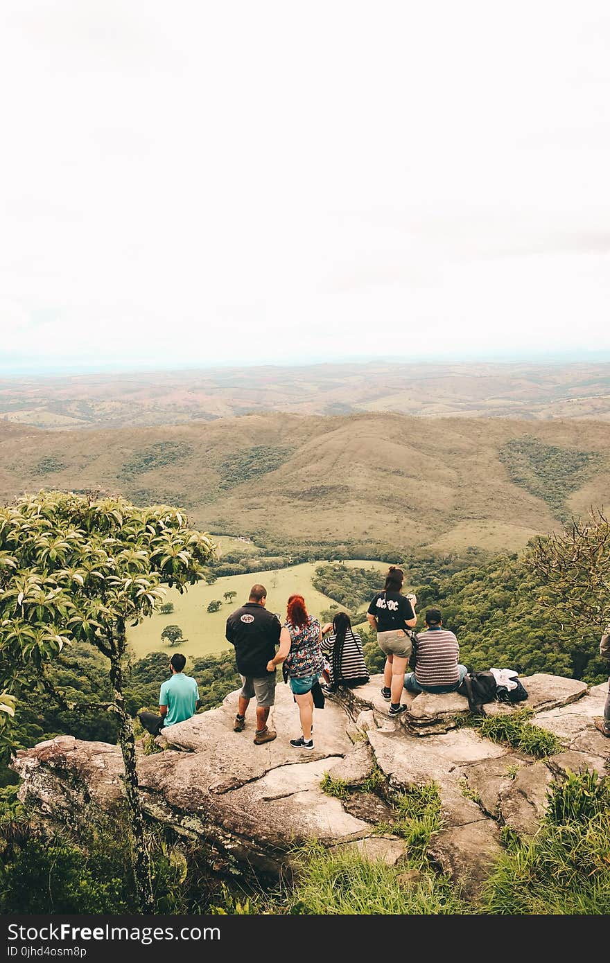 People Sitting and Standing on the Edge If Cliff