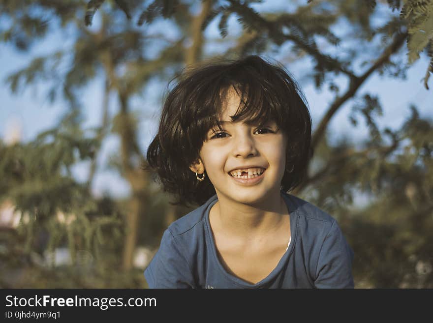 Shallow Focus Photography of Girl Wearing Blue Shirt