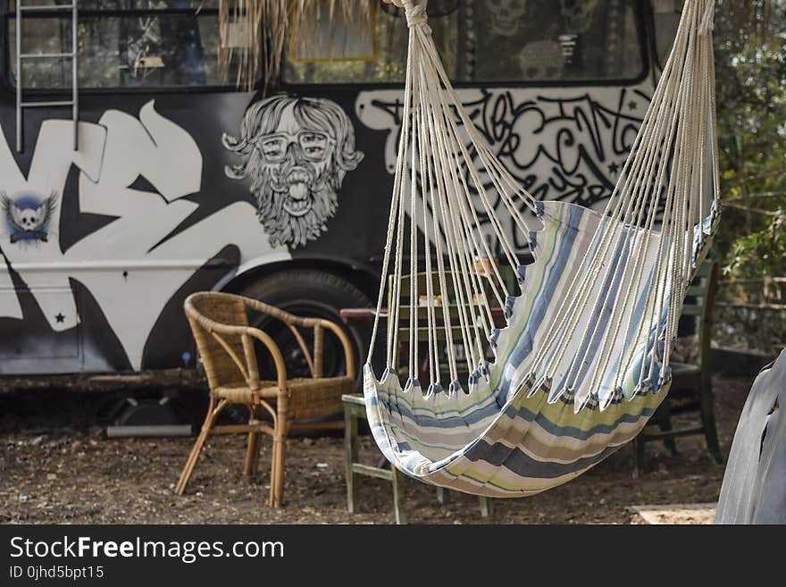 Multicolored Hammock Near Brown Rattan Armchair