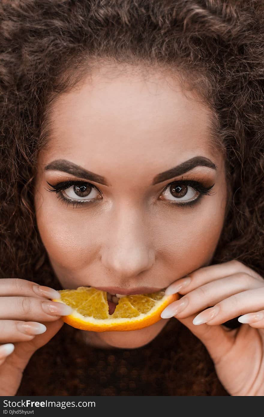 Close-Up Photography of a Woman Eating Orange