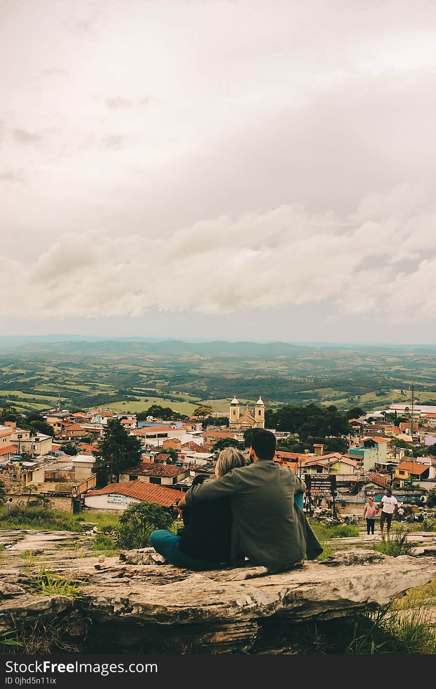 Couple Sitting On Cliff Of The Hill