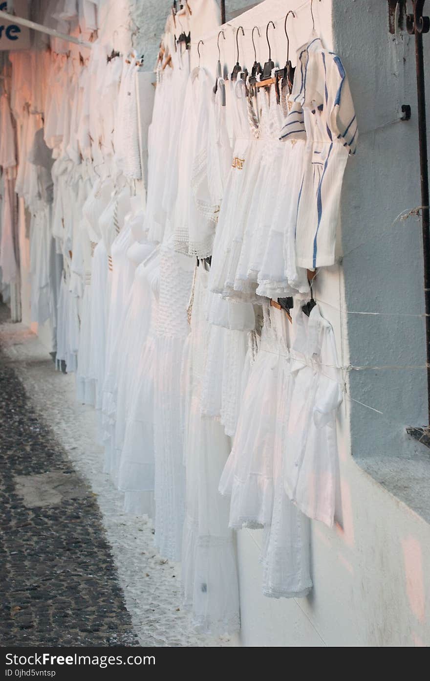 Assorted Dresses Hanged on White Painted Wall