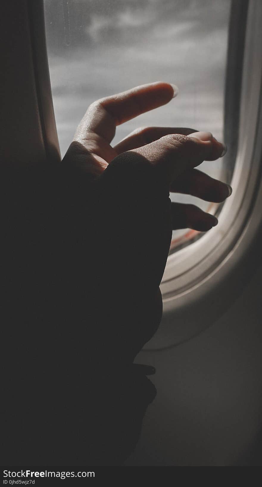 Hand By Airplane Window