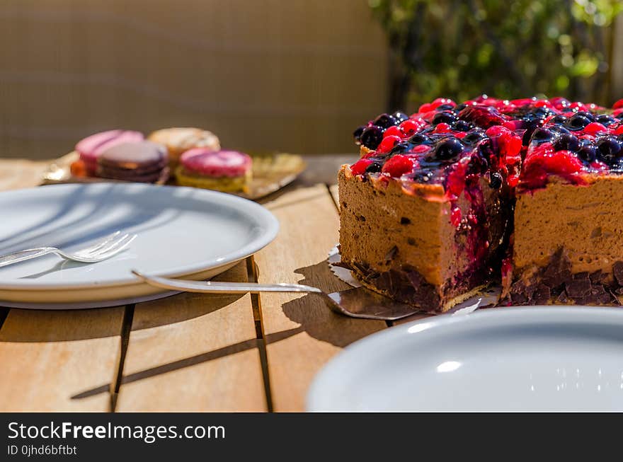 Cake Near White Ceramic Plate on Brown Wooden Table