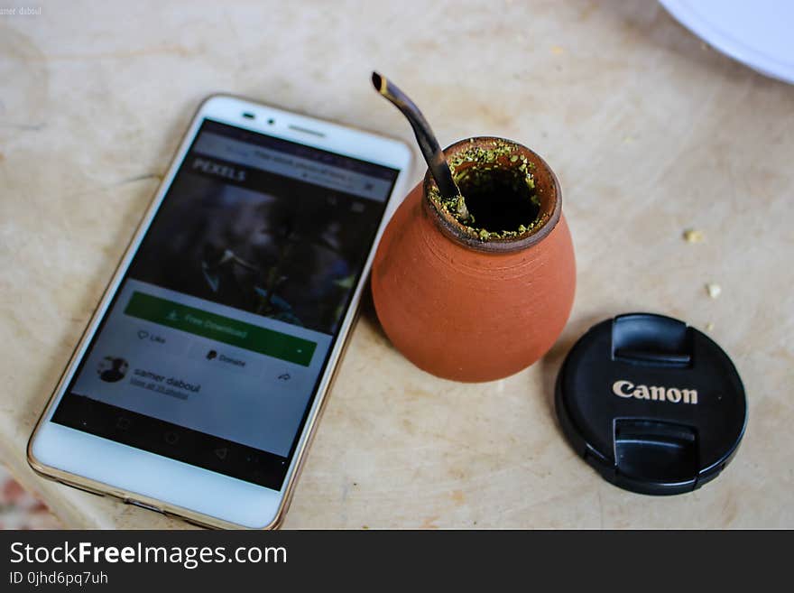 White Android Smartphone Beside Brown Ceramic Pot