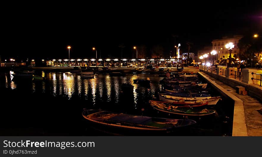 White Boats Near Gray Post Light during Night Time